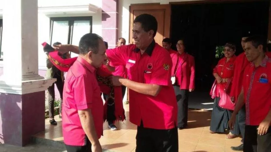 Ketua DPC PDI Perjuangan Sumba Barat Alexander Reda Mata Dapawole memasangkan baju partainya untuk pasangan calon dukungannya. (net)